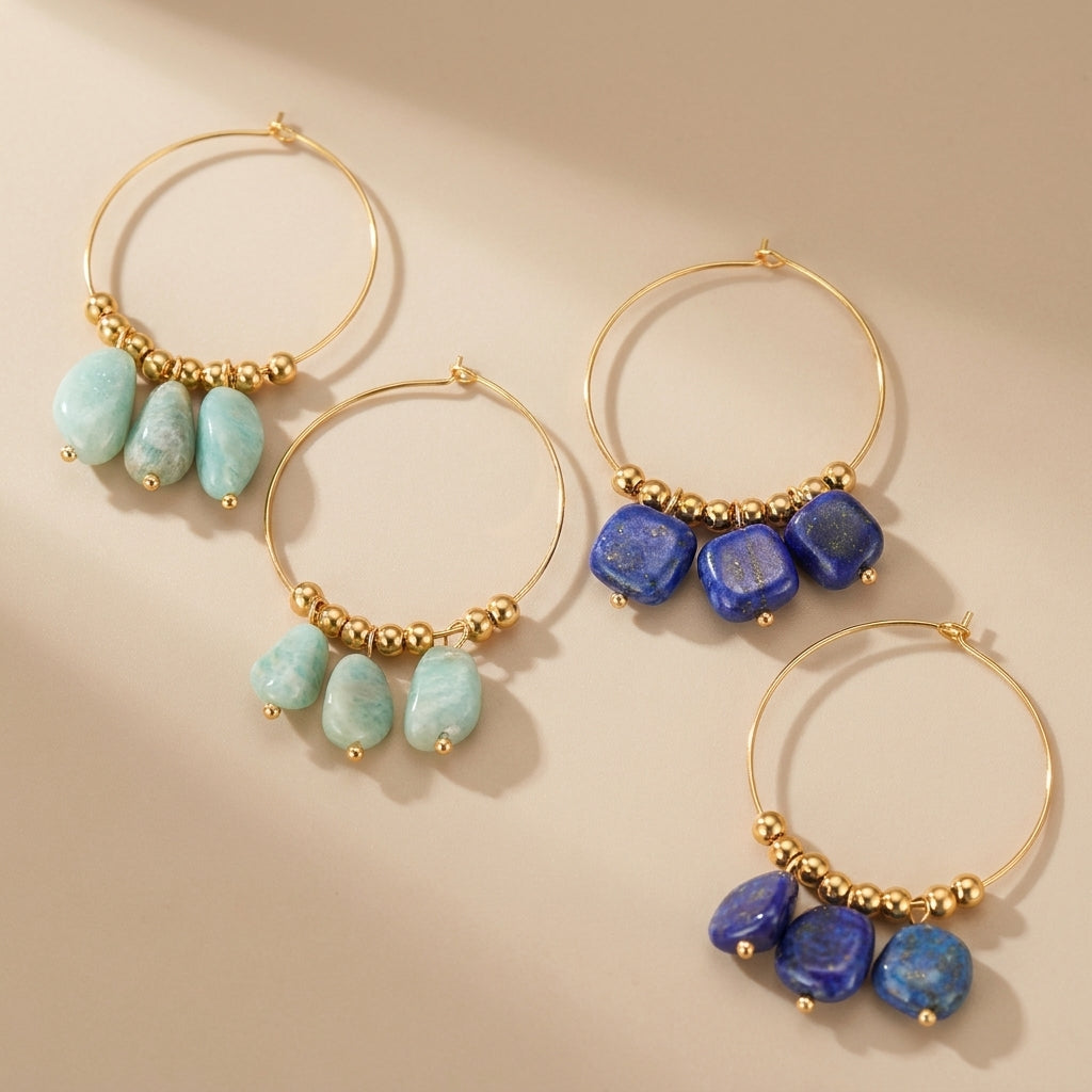 Deux paires de boucles d'oreilles créoles dorées ornées de perles dorées et de pierres naturelles bleues (lapis lazuli) ou vertes (amazonite). @main