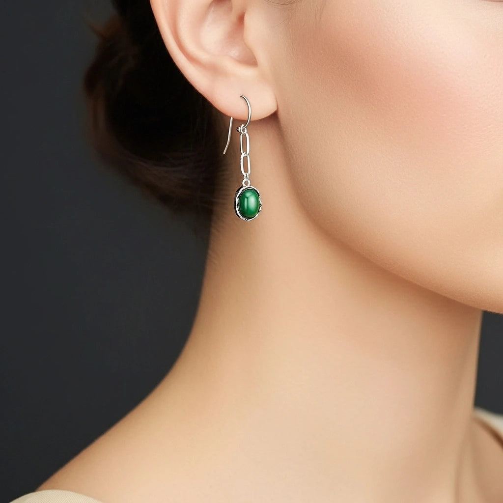 Boucle d'oreille élégante en argent avec une pierre verte ovale de malachite, suspendue à une chaîne à maillons.