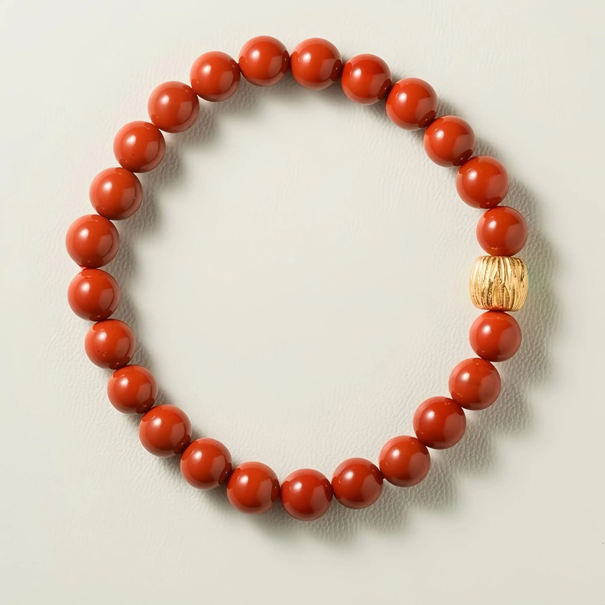 Bracelet artisanal en agate rouge naturelle avec fermoir en argent plaqué or, vue rapprochée sur fond blanc.