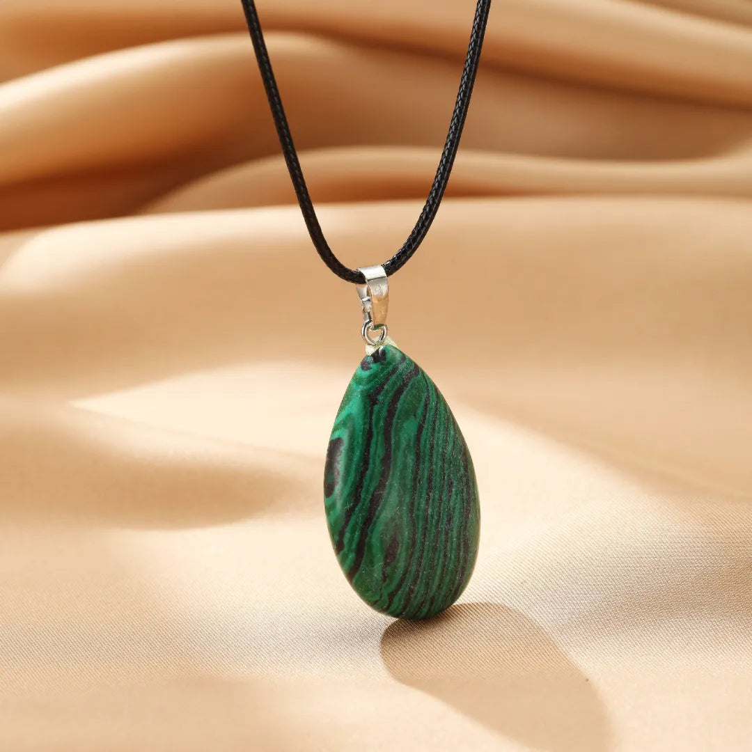 Collier avec pendentif en forme de goutte en malachite verte et noire, monté sur un cordon noir.