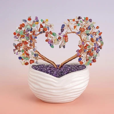 Arbre de Vie en forme de cœur avec des pierres multicolores et une base remplie de cristaux violets dans un pot blanc texturé.