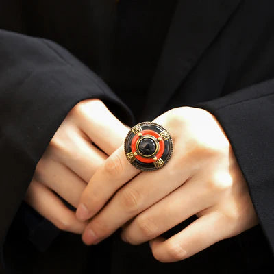 Bague "Merveille d'Antan" en argent vieilli avec une agate noire centrale et des détails émaillés rouges et noirs, ornée de motifs celtiques.