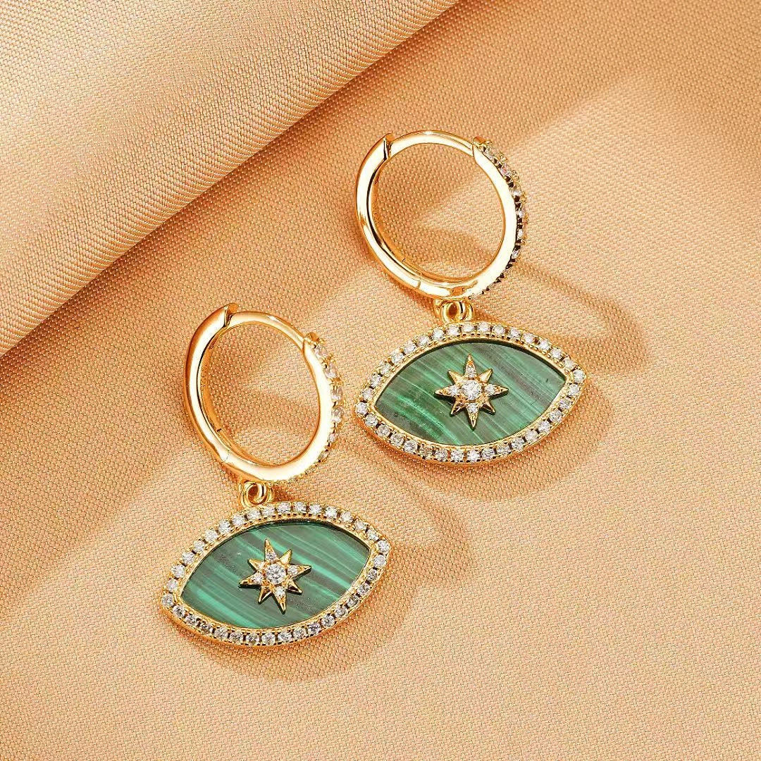 Paire de boucles d'oreilles pendantes en argent doré ornées de malachite verte en forme d'œil, serties de zircons et d'une étoile scintillante au centre.