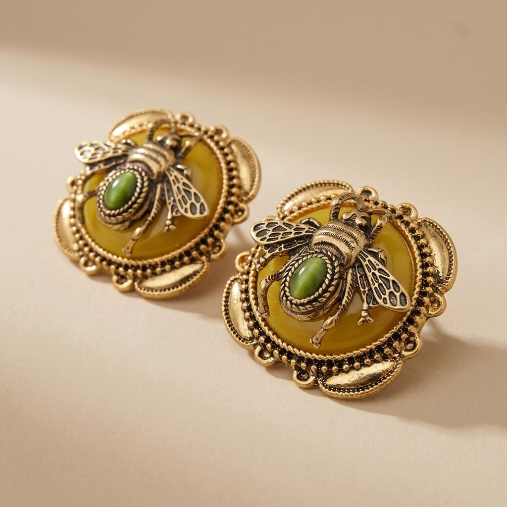 Boucles d'oreilles "Abeille Dorée" en agate avec un design d'abeille antique doré et une pierre verte au centre, sur fond blanc. @main
