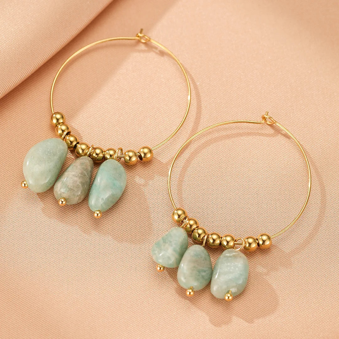 Boucles d'oreilles créoles dorées ornées de perles dorées et de pierres d'amazonite naturelles aux teintes douces de vert et de gris.