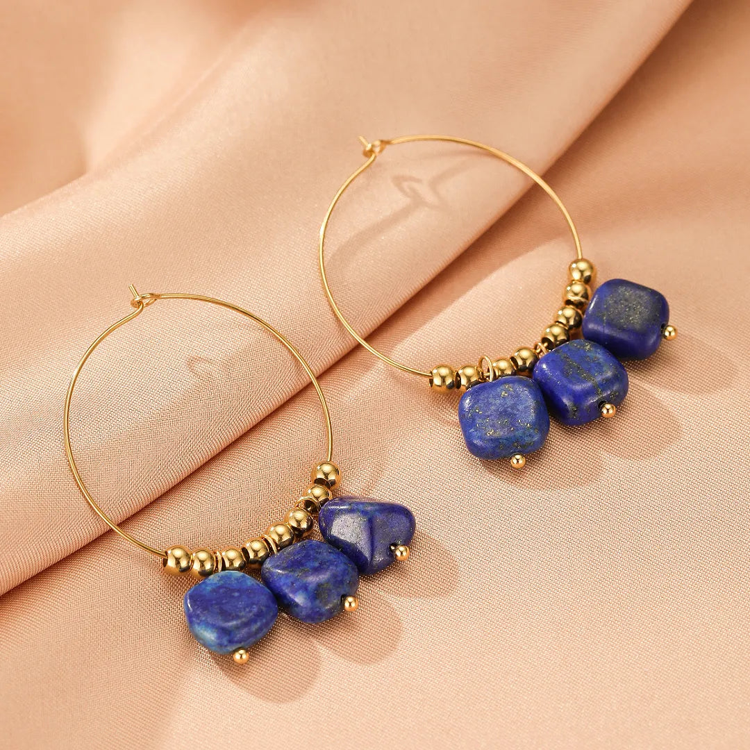 Boucles d'oreilles créoles dorées ornées de pierres bleues en lapis lazuli et de perles dorées.