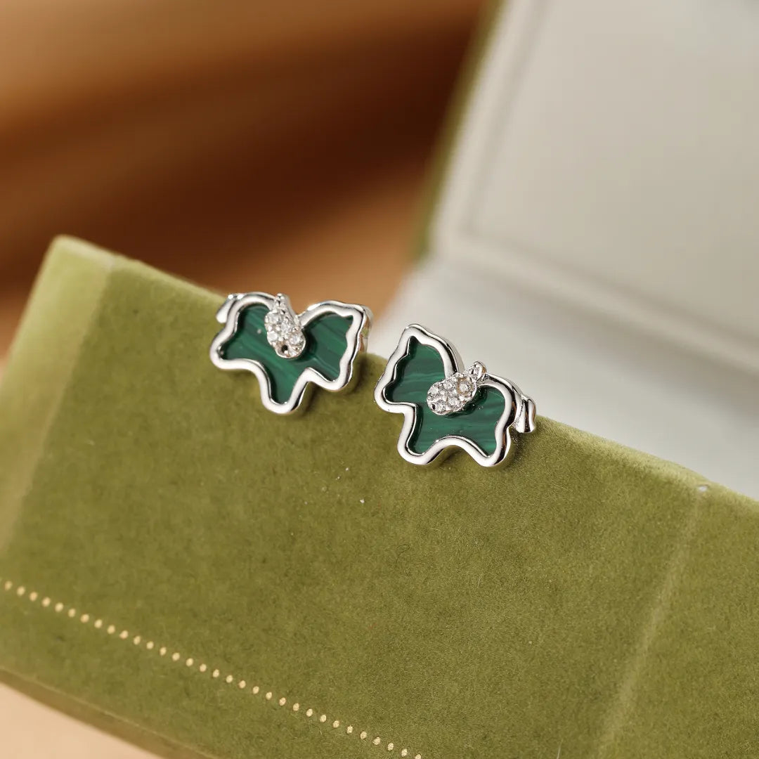 Boucles d'oreilles en argent ornées de malachite verte et de petites pierres scintillantes, en forme de cheval stylisé.