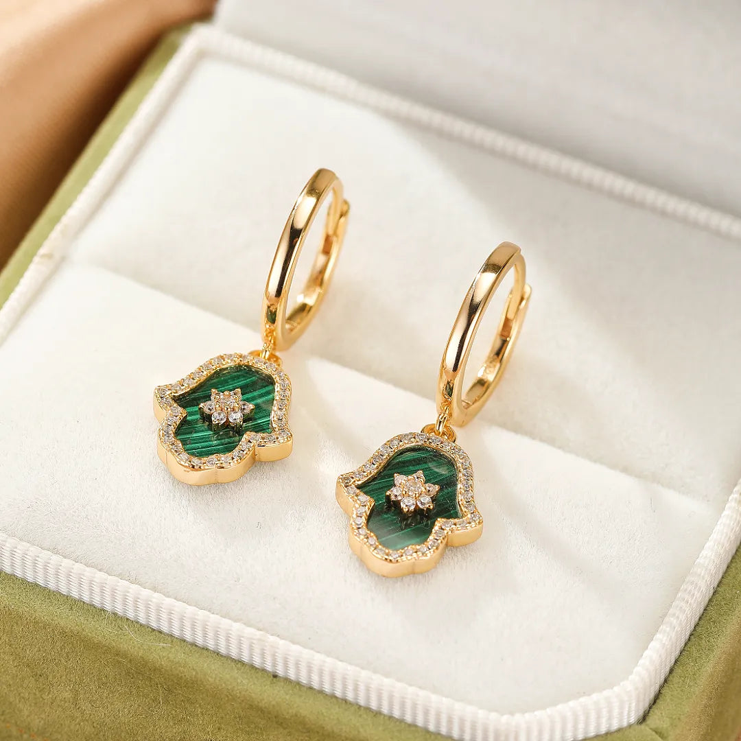 Boucles d'oreilles pendantes en argent doré ornées de malachite verte et de diamants, en forme de main protectrice Hamsa.