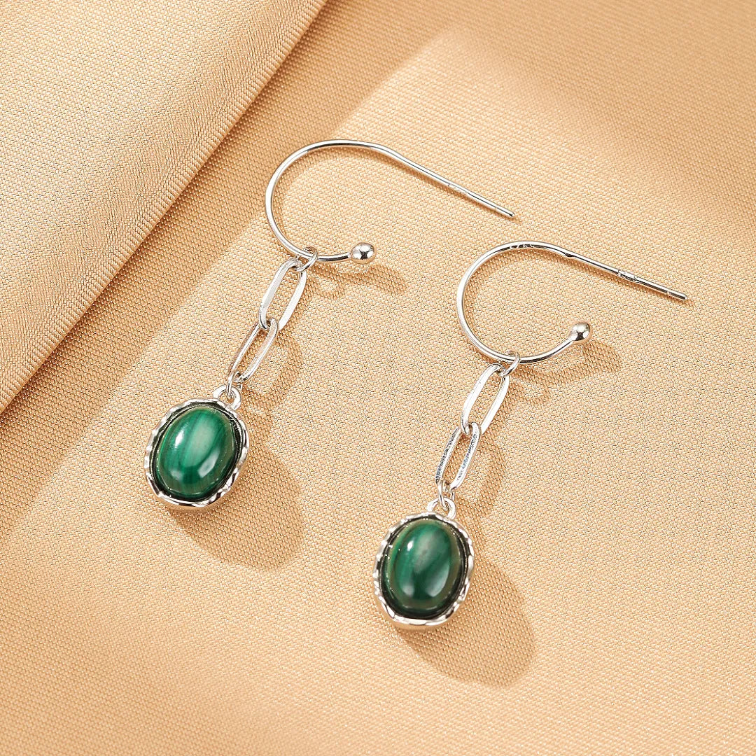 Paire de boucles d'oreilles pendantes en argent 925 avec une pierre d'œil de tigre ou de malachite ovale sertie sur un motif de chaîne.