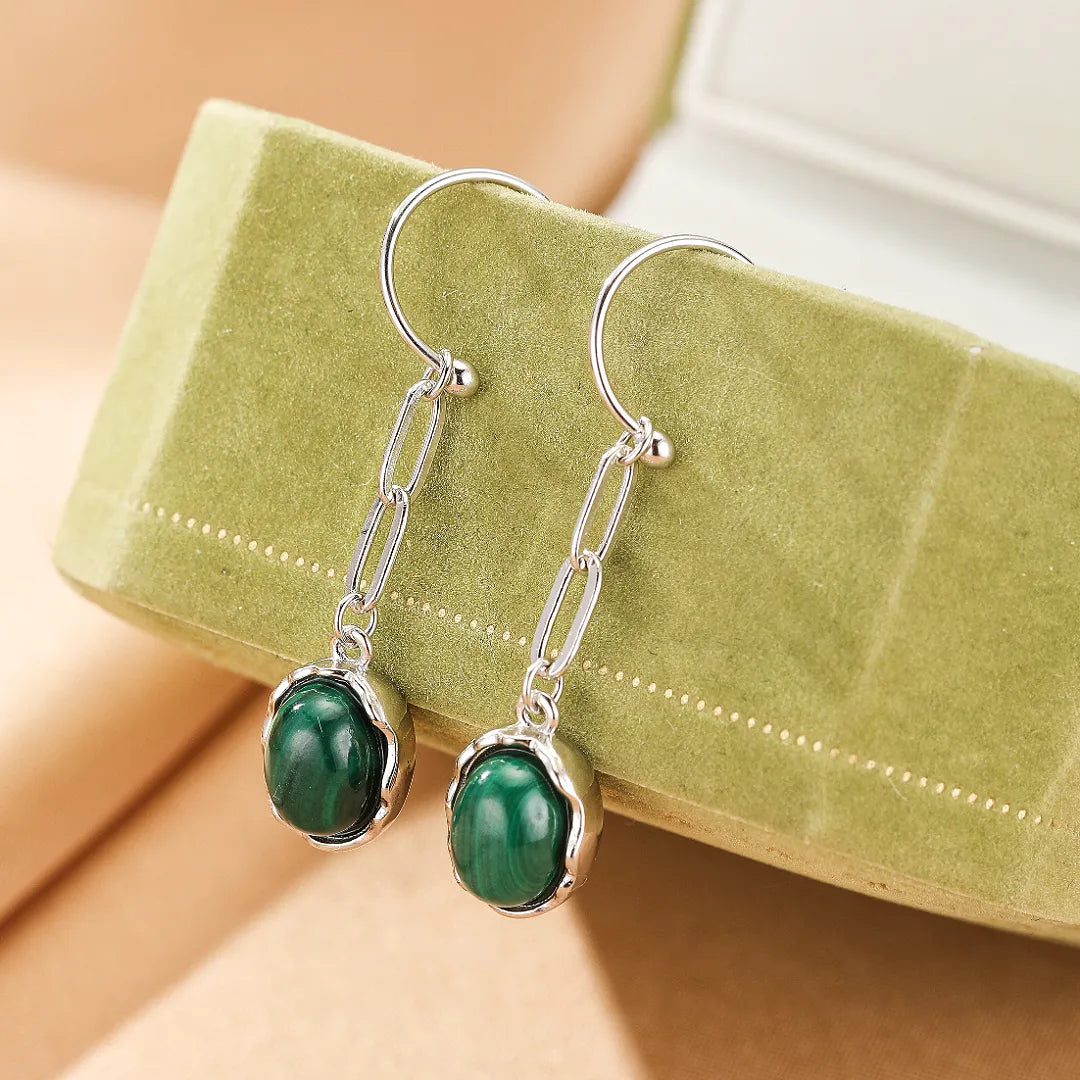 Boucles d'oreilles pendantes en argent avec une pierre de malachite verte brute, montées sur une chaîne à maillons.