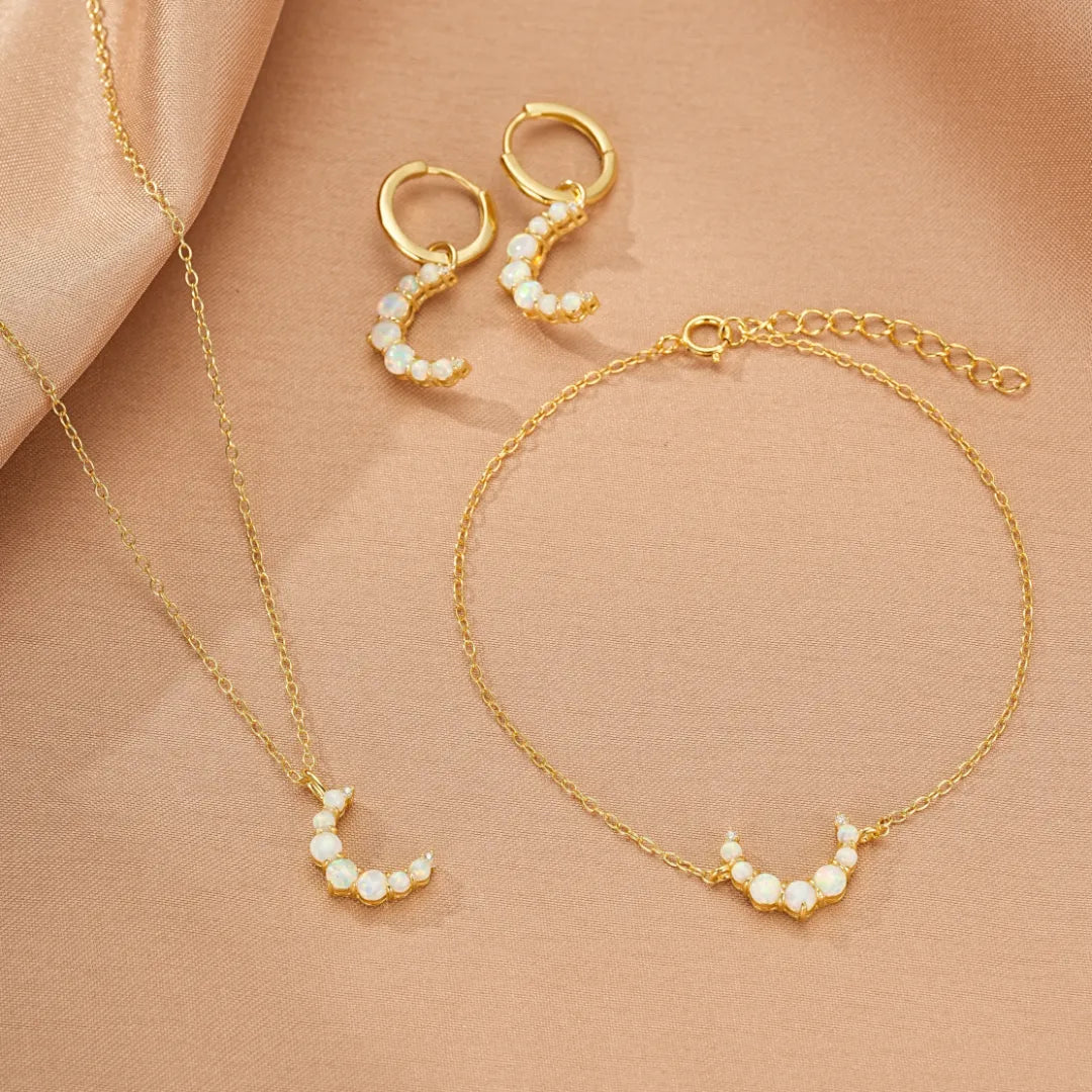 Ensemble de bijoux en argent doré 18 carats avec opales, comprenant des boucles d'oreilles en forme de croissant de lune, un collier et un bracelet.