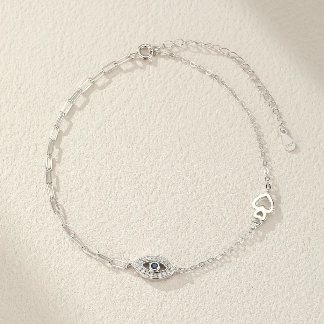 Bracelet de cheville en argent 925 avec un pendentif œil bleu entouré de cristaux et un motif de cœur ajouré.