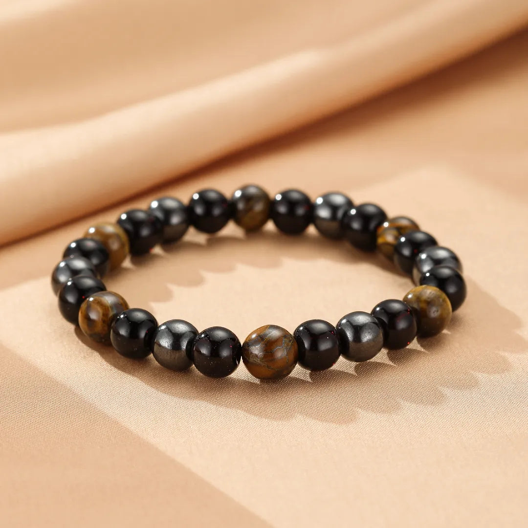 Bracelet de perles en œil de tigre et hématite, symbolisant la force protectrice.