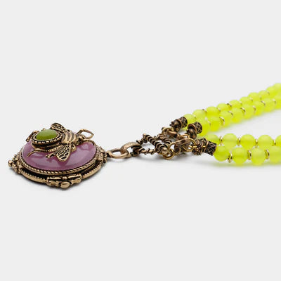 Collier avec pendentif en forme d'abeille dorée sur une agate rose entourée de perles jaunes