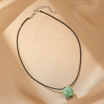 Collier Aventurine "Sérénité du Cœur" avec une pierre verte ronde sur un cordon noir réglable.