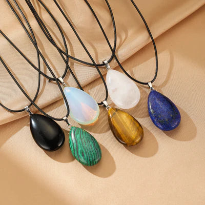 Ensemble de colliers avec pendentifs en forme de goutte de pierres naturelles variées : œil de tigre, obsidienne, malachite, opaline, quartz rose et lapis-lazuli.