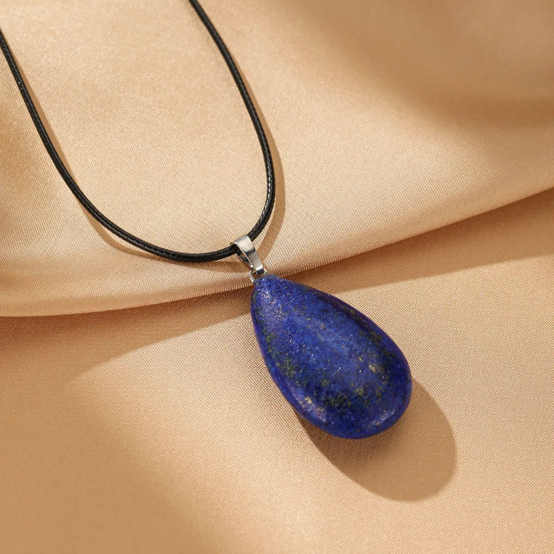 Collier en argent avec un pendentif en forme de goutte de Lapis Lazuli bleu profond, monté sur un cordon noir.