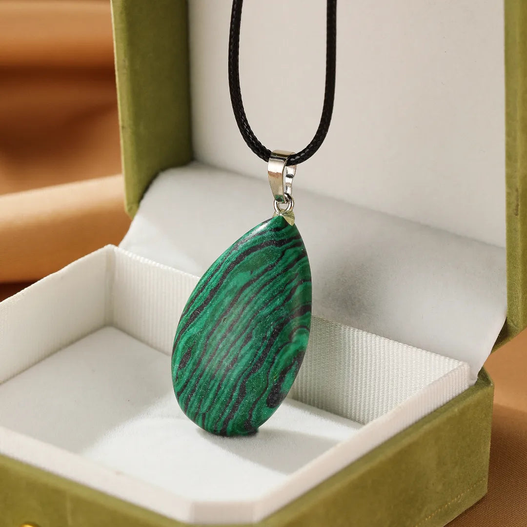 Collier "Rayons de Vitalité" avec pendentif en malachite verte et noire en forme de goutte, présenté dans un écrin.