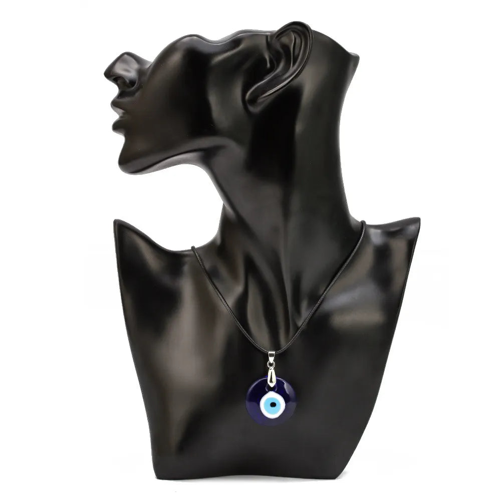 Collier œil bleu sur un mannequin noir, le pendentif est un œil de protection bleu et blanc.