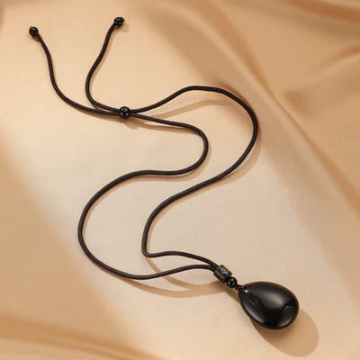 Collier avec pendentif goutte d'obsidienne noire, sur cordon réglable noir.