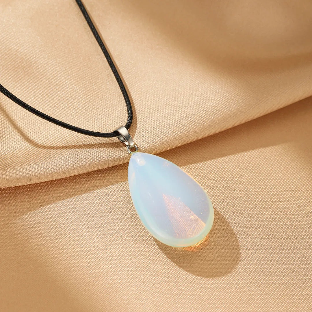 Collier Opale "Aura Douce" avec un pendentif en forme de goutte d'eau opale blanche irisée sur un cordon noir.