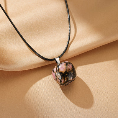 Collier "Douceur Naturelle" avec un pendentif en rhodonite brute rose et noire, monté sur un cordon noir.
