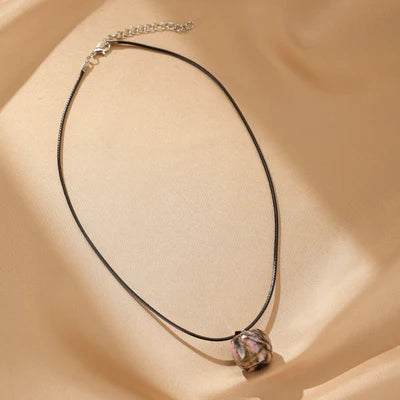 Collier "Douceur Naturelle" avec une perle unique en rhodonite aux reflets roses et verts, sur un cordon noir réglable.