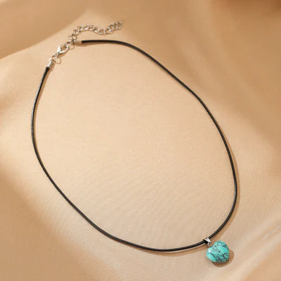 Collier ras du cou avec un pendentif en forme de cœur de turquoise brute sur une chaîne fine et discrète.