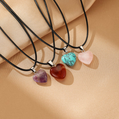 Collection de colliers en forme de cœur avec des pierres brutes : turquoise, rose, améthyste et rouge.