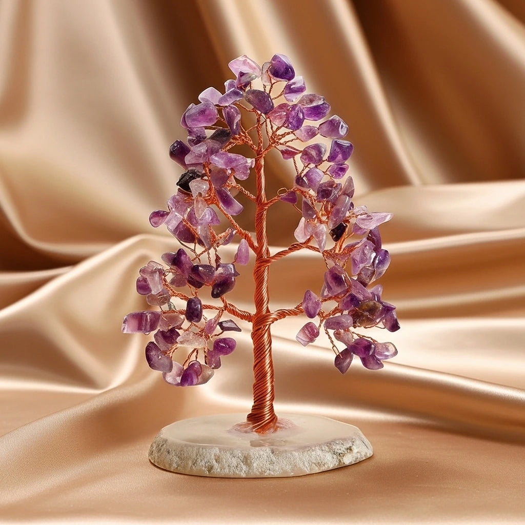 Arbre de vie décoratif fait de pierres d'améthyste violettes et d'un fil de cuivre, posé sur une base en agate blanche, sur un fond satiné doré.